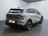 the rear end of a silver car in a white room