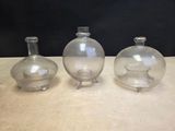 three clear glass vases sitting on top of a wooden table