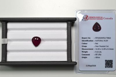 un gros plan sur un diamant rouge en forme de cœur dans un écrin