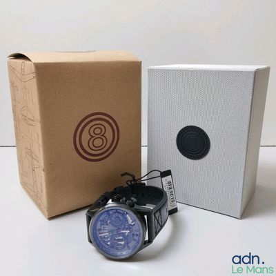 une montre posée à côté d'une boîte sur une table