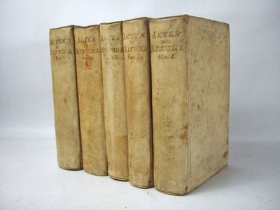 three old books sitting on top of each other on a white surface