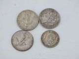 four different types of coins are shown on a white surface