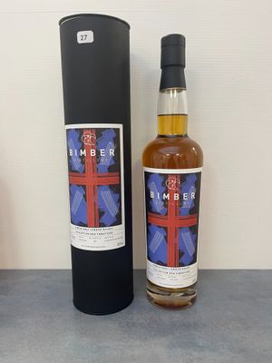 une bouteille de whisky posée à côté d'une boîte noire sur une table