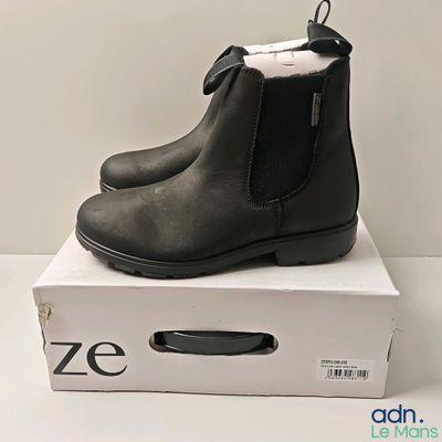 les bottines noires sont posées sur une boîte blanche