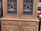 un meuble en bois avec une porte en verre dans une pièce
