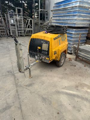 a yellow truck that is parked in front of a pile of metal