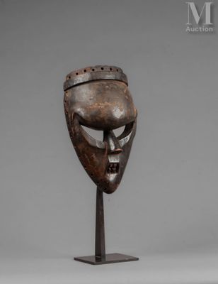a wooden mask on a metal stand with a gray background