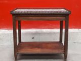 a wooden table with a shelf on top of it in front of a red wall
