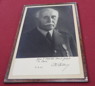 une vieille photo d'un homme en uniforme militaire posé sur une table rouge