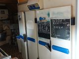 several refrigerators are lined up in a kitchen with a chalk board on the wall