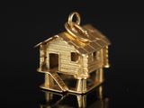 un pendentif en or sur lequel est représentée une petite maison