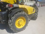 a yellow tractor that is parked in a parking lot