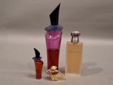 a small bottle of perfume next to a small bottle of perfume