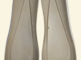 pair of nude colored shoes with clear heels sitting on a white surface