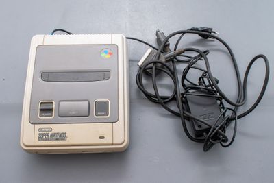 une console de jeux Nintendo Classic posée à côté d'un chargeur sur une table