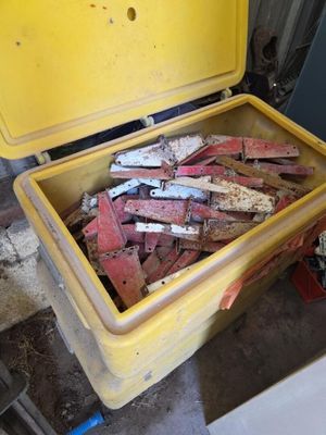 une grande caisse jaune remplie de briques et d'outils