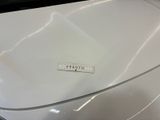a close up of a white car with a ruler on it ' s hood