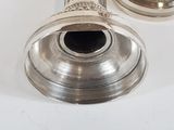 a silver trumpet that is sitting on a white table