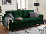 a green couch sitting in a living room next to a coffee table