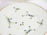 three plates with flowers on them sitting on a table