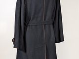 black coat on a mannequin stand on a white background