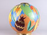 a colorful vase that is sitting on a white surface