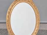 un miroir au cadre doré ouvragé posé sur un sol en damier