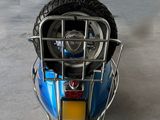 a blue scooter parked in a garage with a rack on the back of the scooter