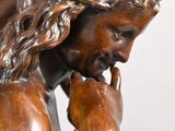 bronze statue of a man holding his head in his hands