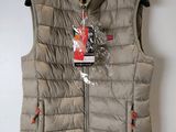 a vest that has a tag on it hanging on a wall