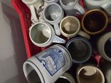 a red basket full of coffee cups and mugs