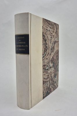 un vieux livre posé sur une table blanche à côté d'un mur blanc