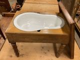 a wooden chair that has a sink in it