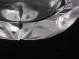 a clear glass ashtray with a candle inside of it