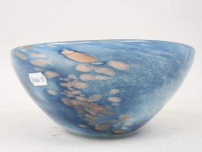 un bol bleu posé sur une surface blanche