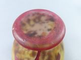 a close up of a red and yellow vase on a white surface