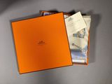 an orange box containing a pair of shoes and a pair of cards