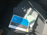 une photo du tableau de bord d'une voiture sur lequel se trouvent un livre et un téléphone portable