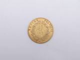 a close up of a gold coin on a white surface