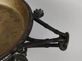 a metal bowl with a handle on a white surface