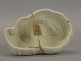 a white bowl with a tag on it sitting on a table