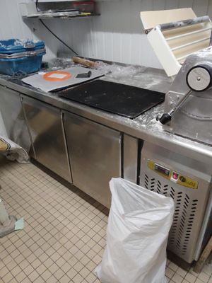 une machine qui se trouve dans une cuisine, à côté d'un sac poubelle