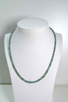 collier composé de perles de verre vertes sur un mannequin blanc