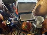 a laptop computer sitting on a table with a cup and saucer