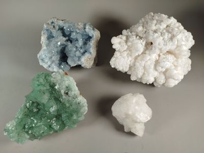 three different colored crystals on a table with a white background