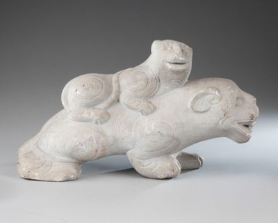 a white sculpture of a bear and a bear with a bird on its back