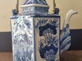 a blue and white teapot sitting on a wooden table