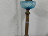 a small blue glass lamp sitting on a wooden table