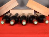 several bottles of wine are lined up on a red table cloth