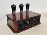 une boîte en bois surmontée de trois boutons noirs